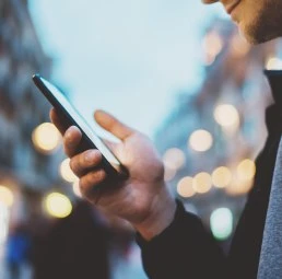 Person Looking At Cell Phone On City Street